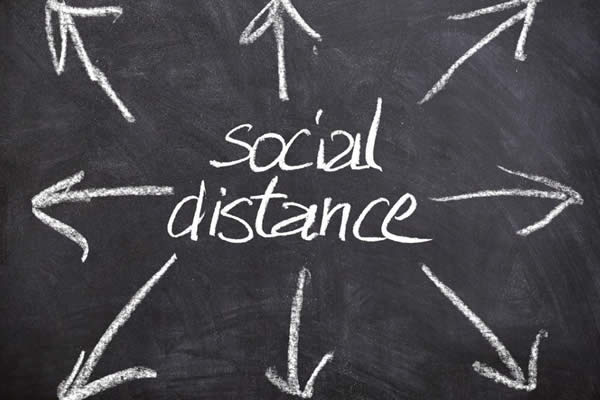 Social distance with outward arrows on a chalkboard.