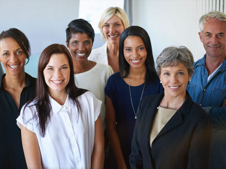 Five women and one man smiling and posing for a professional photo - linkedin advertising